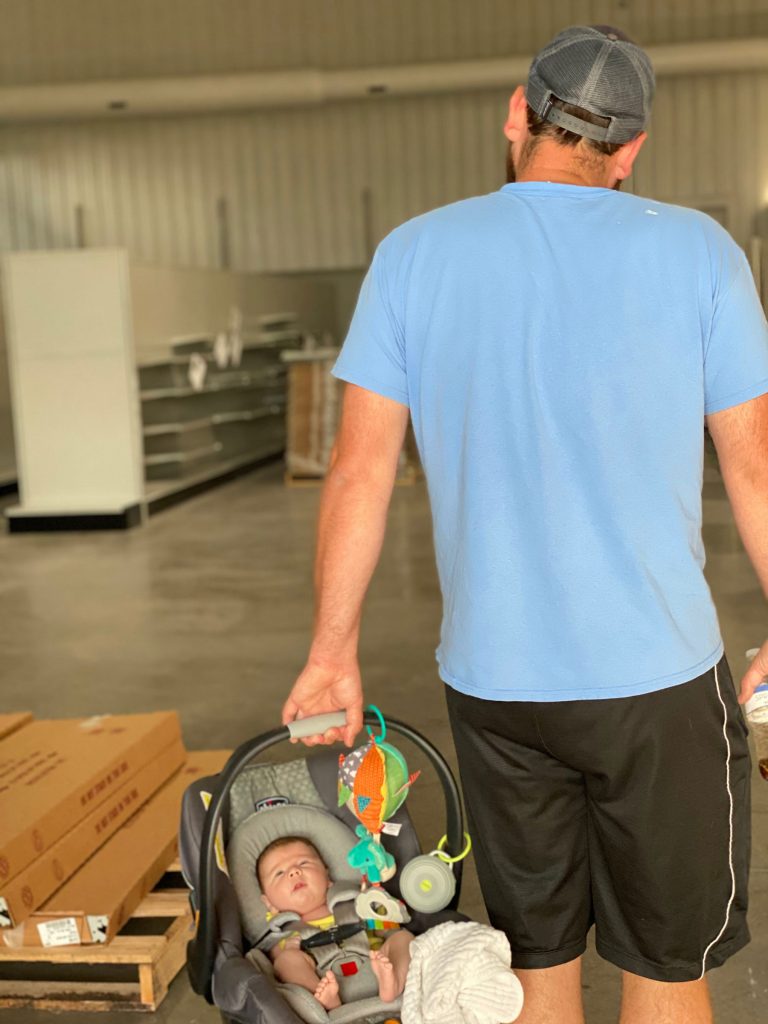 Josh Lowry walking new baby into their new store location before it opened